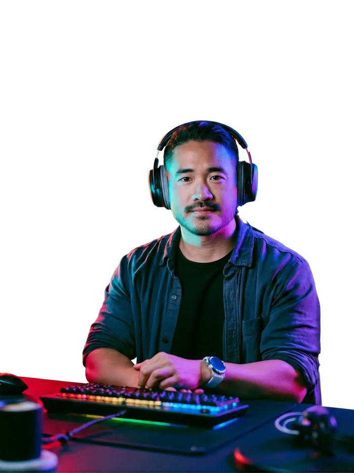An affiliate at his desk in headphones, hands resting on a backlit mechanical keyboard